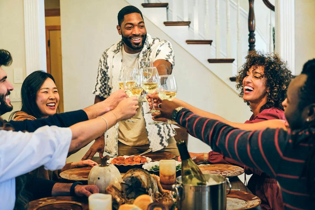 A group of friends celebrating Thanksgiving dinner together in a home
