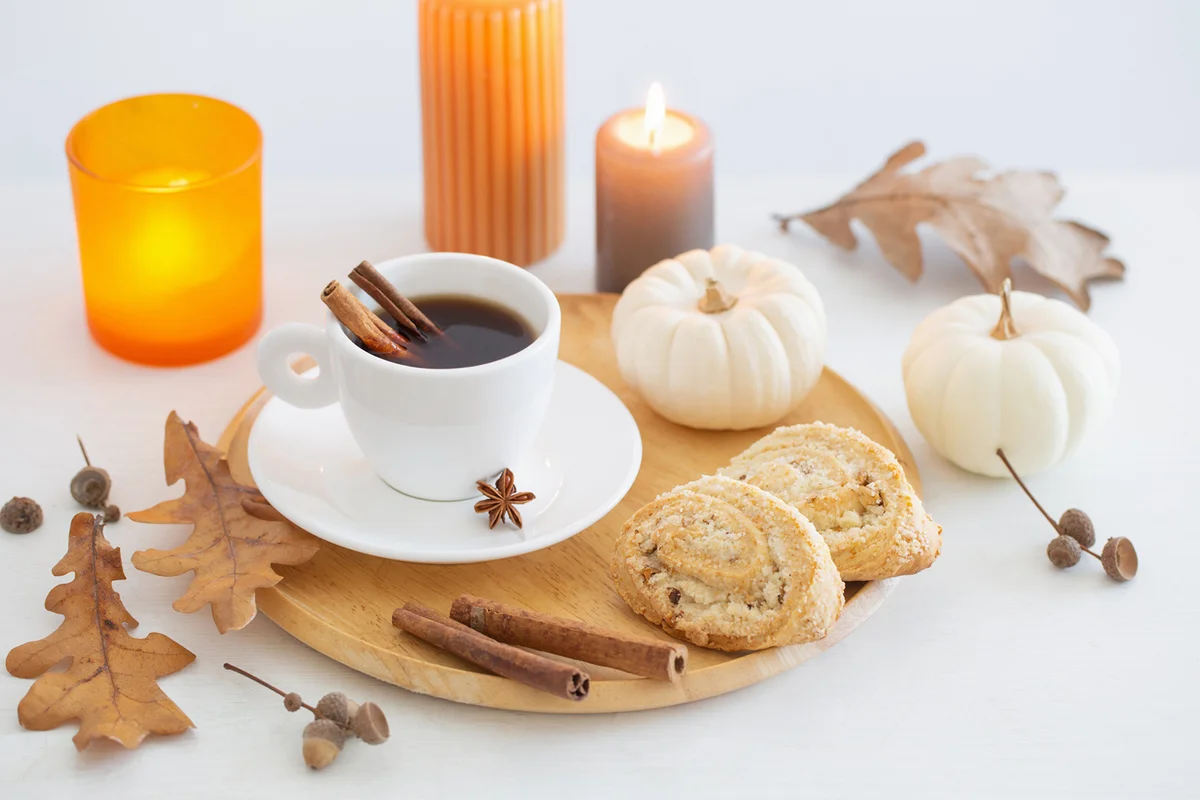 White cup of coffee with cozy decor on white table