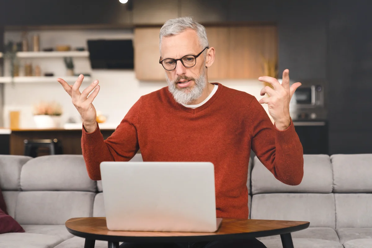 Angry troubled man working on laptop