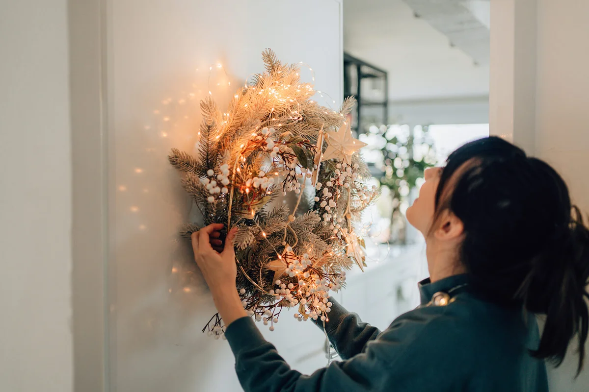 Young woman decorating her living room for the upcoming holidays
