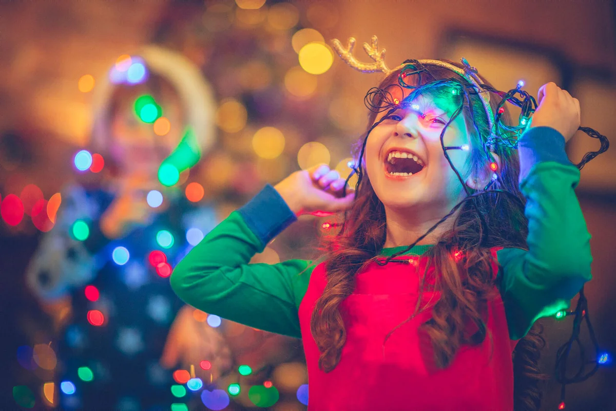 Little girl in Christmas playing with lights