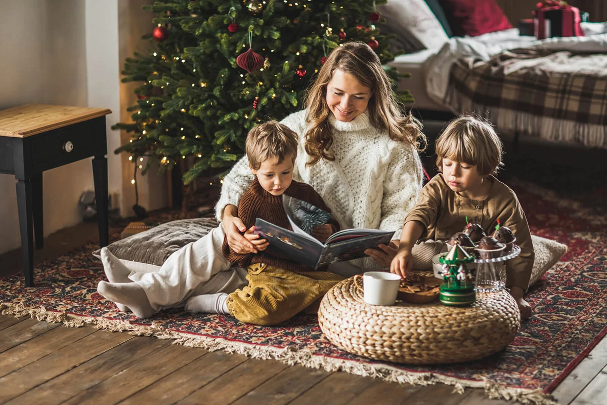 Mother and sons reading Christmas book together