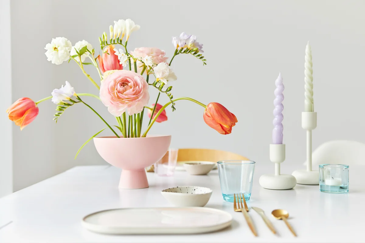 Colorful spring bouquet and candles on table