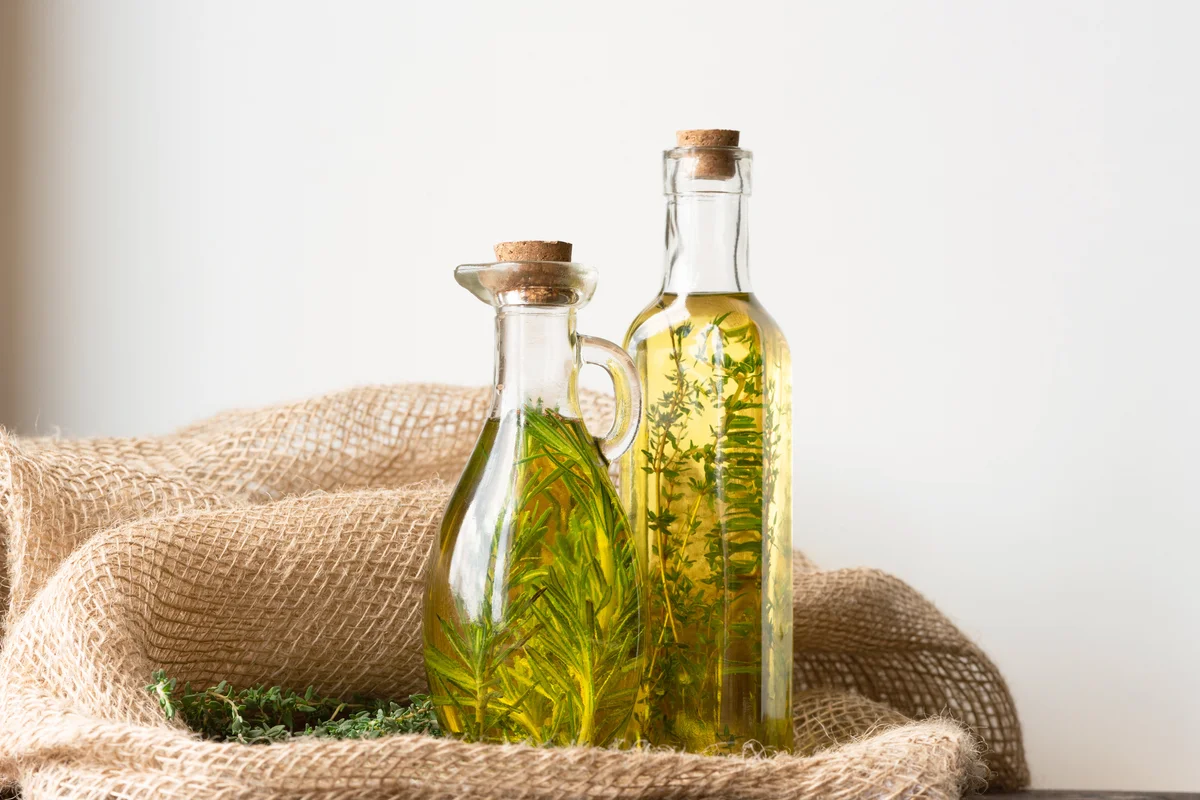 Bottles of olive oil with thyme and rosemary
