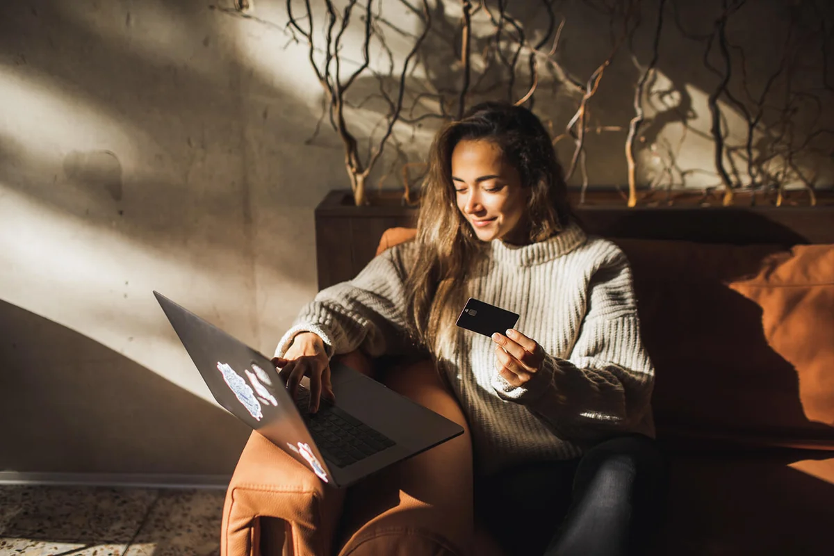 Woman making online purchases in Cafe with Credit Card and Laptop