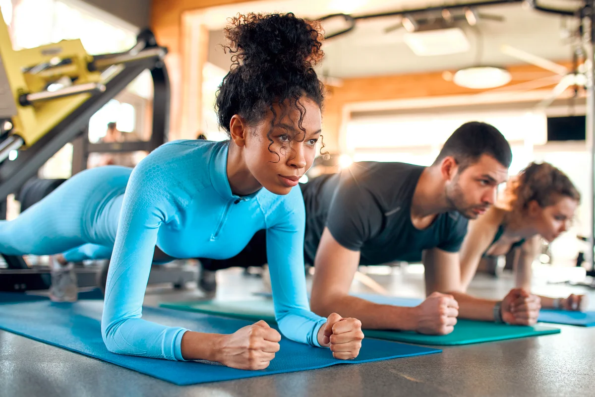 Women in sportswear doing plank exercise in class