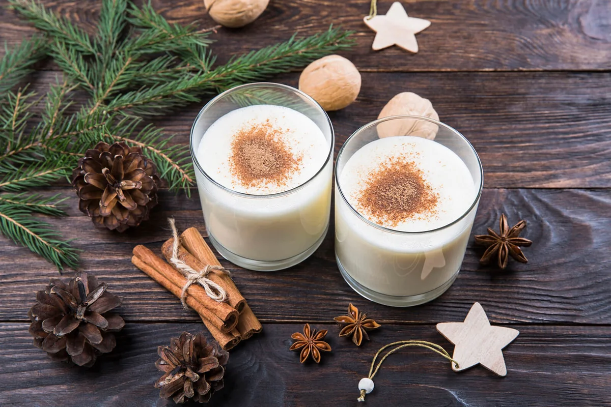Two glasses of eggnog with cinnamon on a table