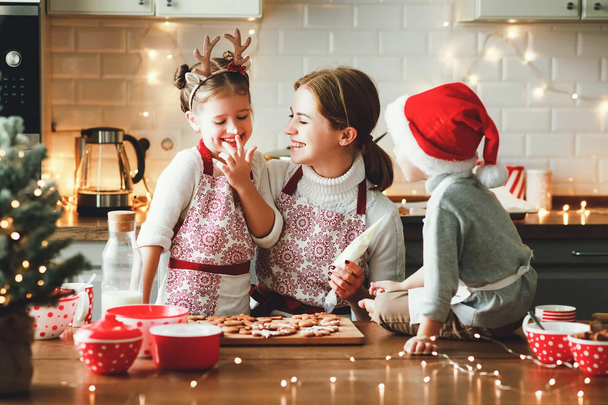 Happy family mother and children bake christmas cookies