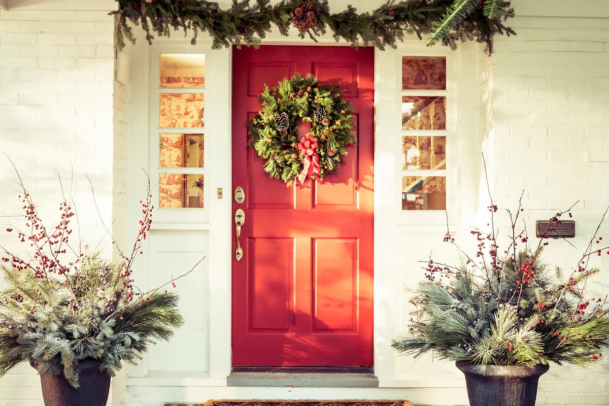 Exterior red door decorated for Christmas
