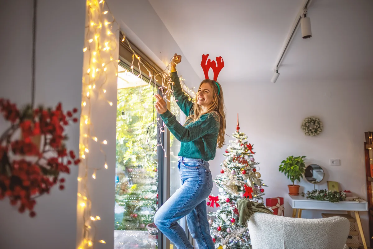 Young woman decorating home for the upcoming Christmas holidays