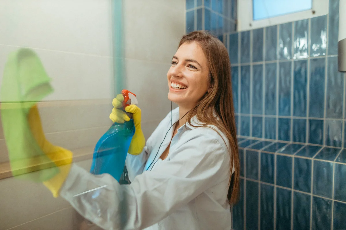 Young woman cleaning bathroom