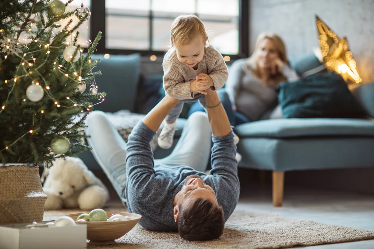 Father and daughter having fun at Christmas decorated living room