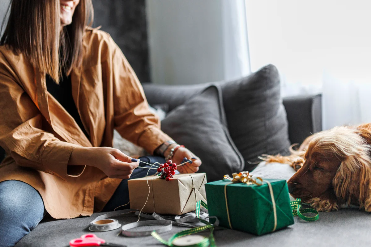 Woman wrapping a gift with her dog