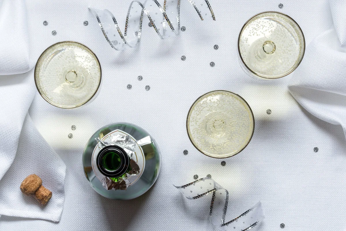 Directly Above Shot Of Champagne Flutes With Bottle On Table