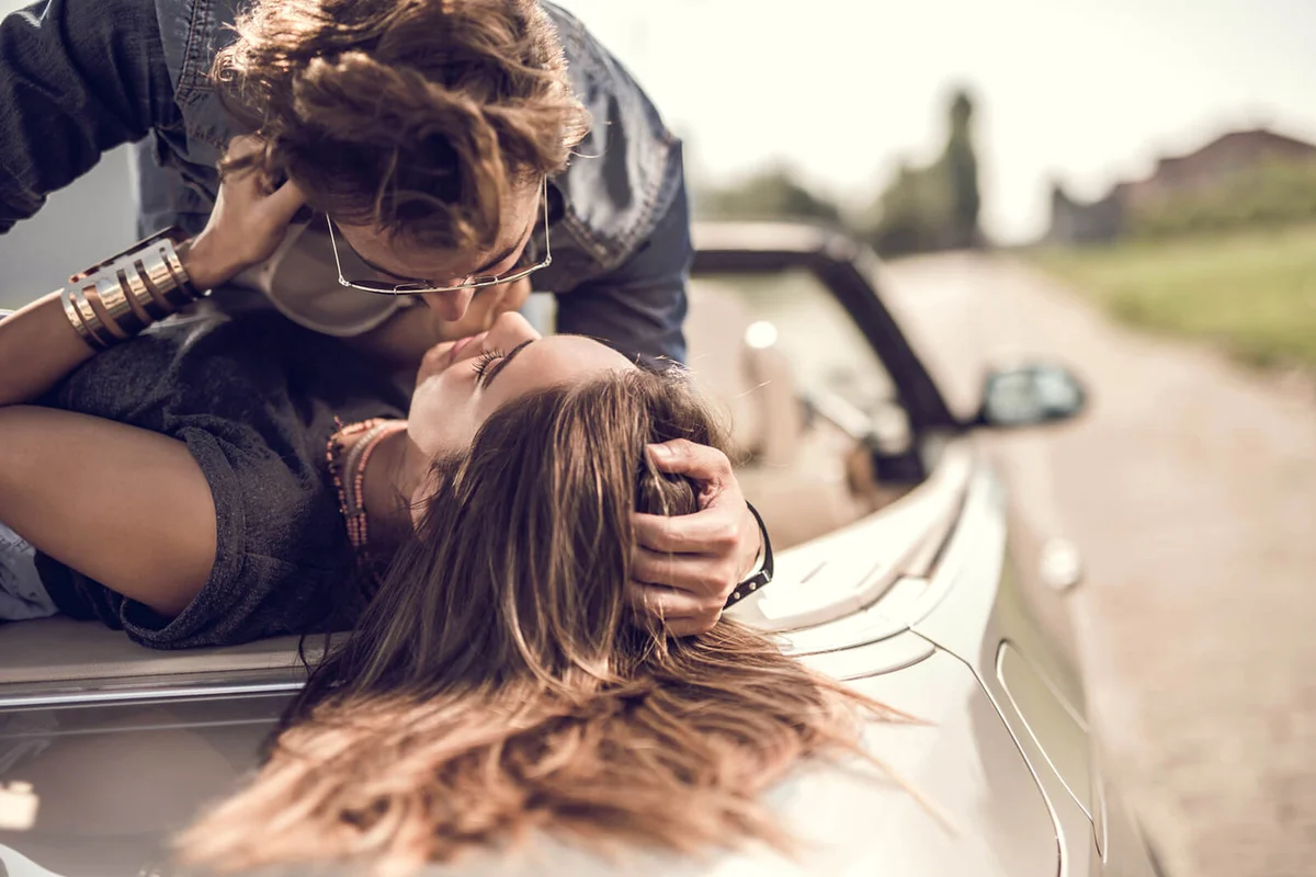 Young romantic couple enjoying in their love on a convertible