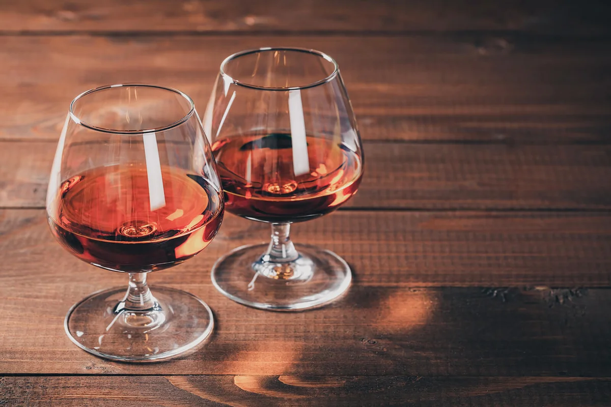 Two glasses of cognac on the wooden table