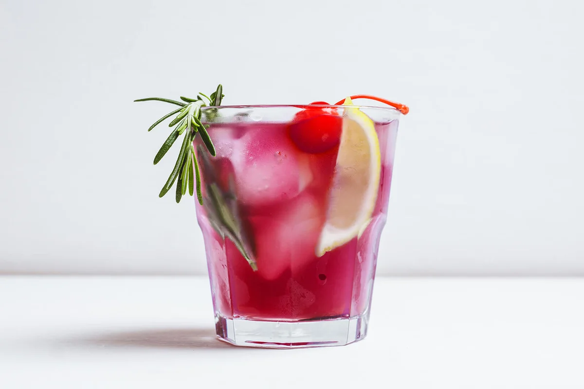 Bitter old-fashioned cocktail with lemon slice and cherry