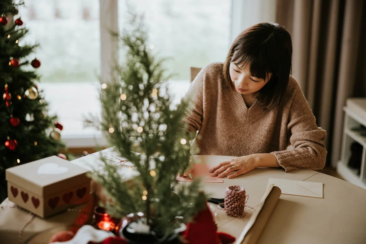 Woman writing a Christmas card to family members