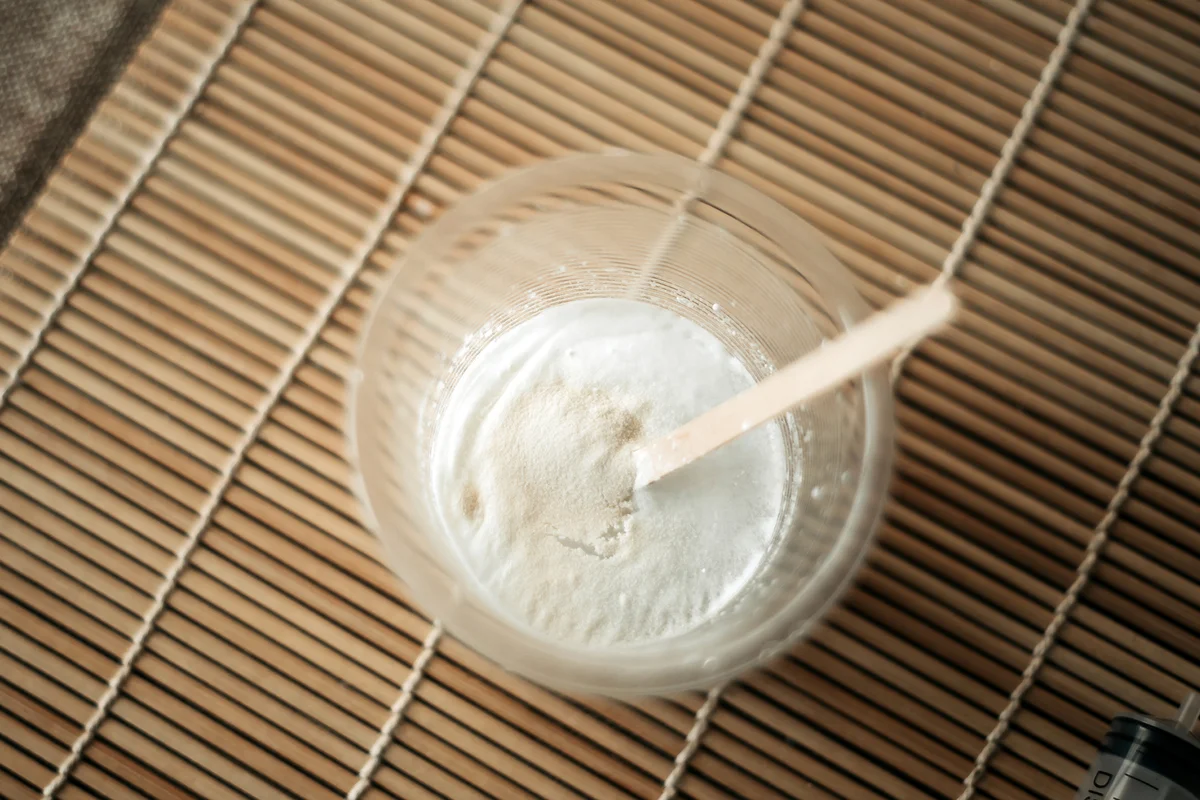 A cup of handmade toothpaste reaches desired consistency on table