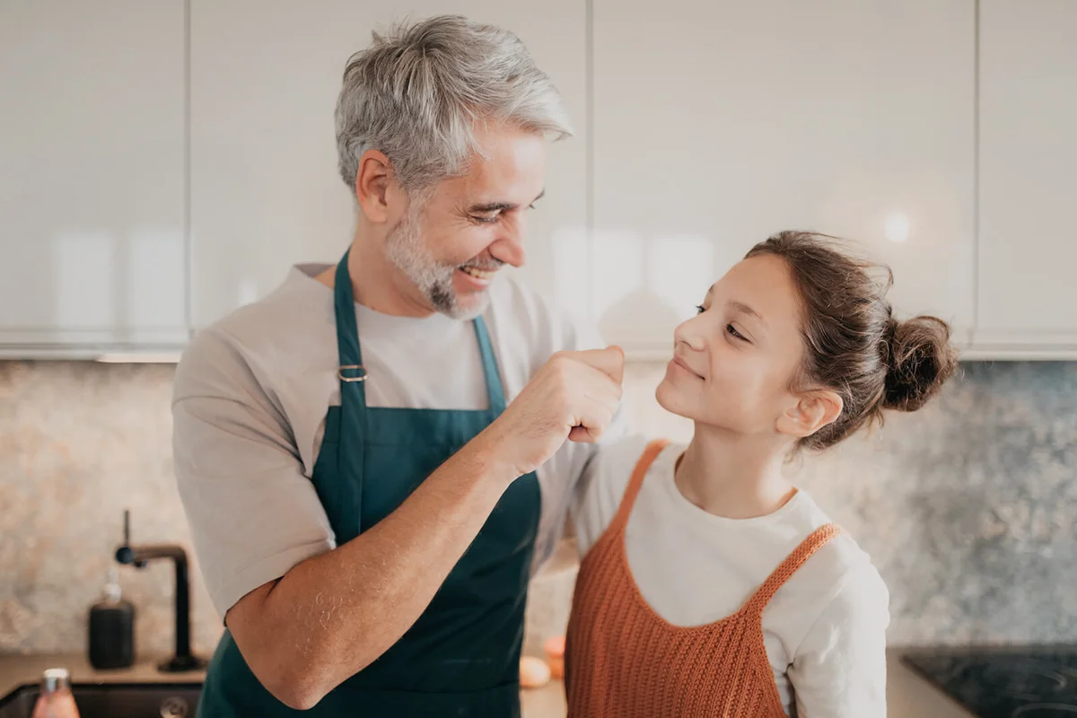 Teenage girl with his father in kitchen together