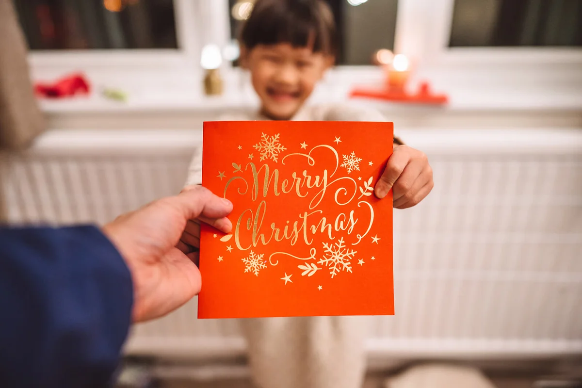 dad receiving a Christmas card given by her lovely cheerful daughter in Christmas at home