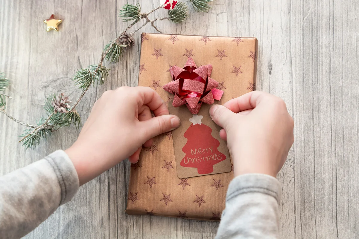 Hands of girl wrapping Christmas present