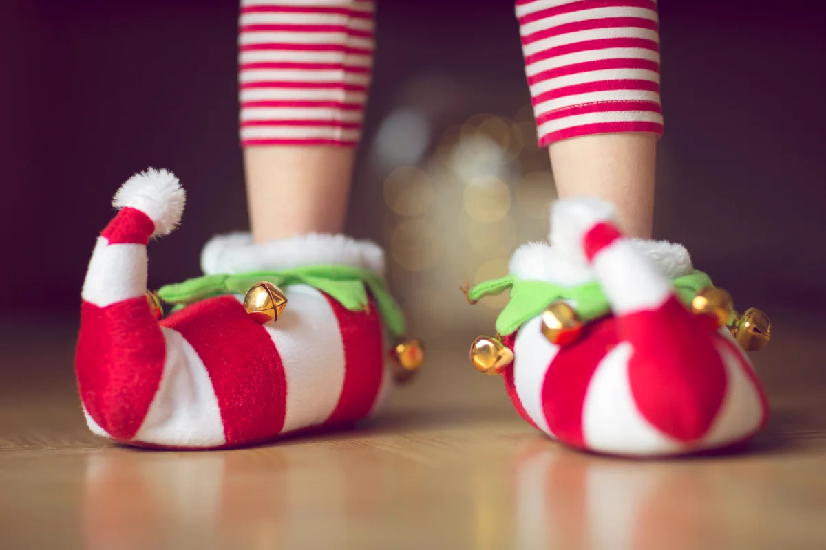 Child wearing Christmas elf novelty slippers with bells