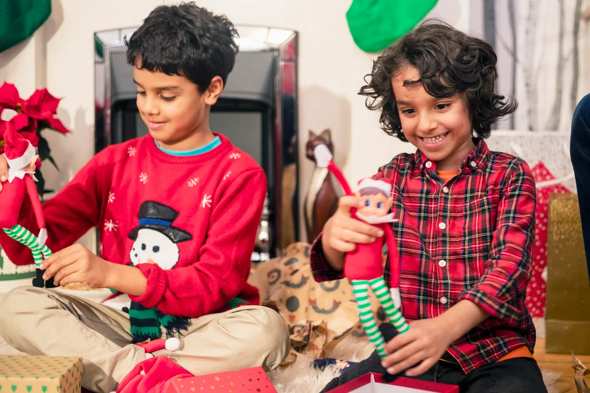 Two young boys opening Christmas presents and getting Christmas elves