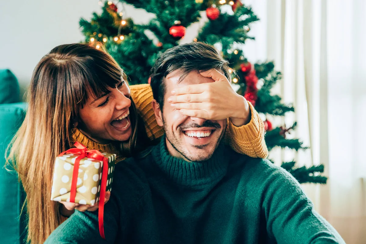 Romantic young couple exchanging Christmas gifts
