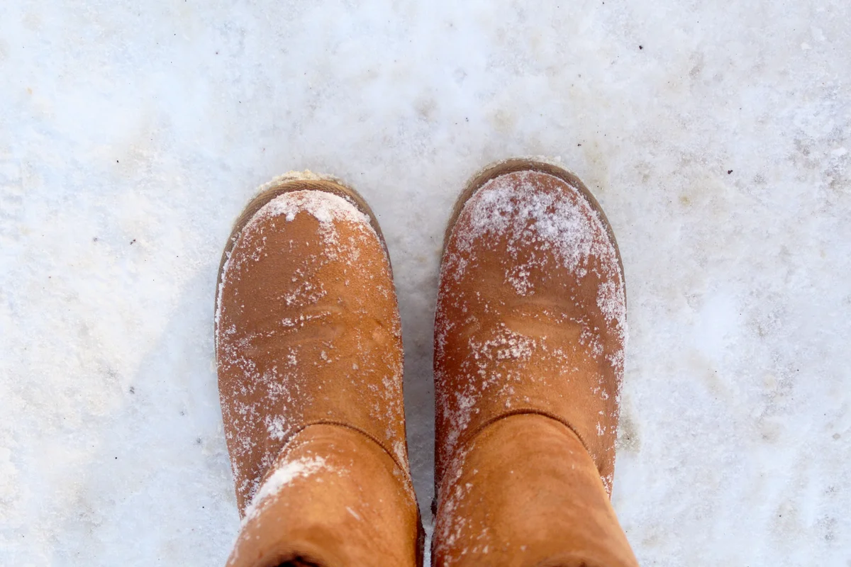 Brown Ugg boots standing in the snow
