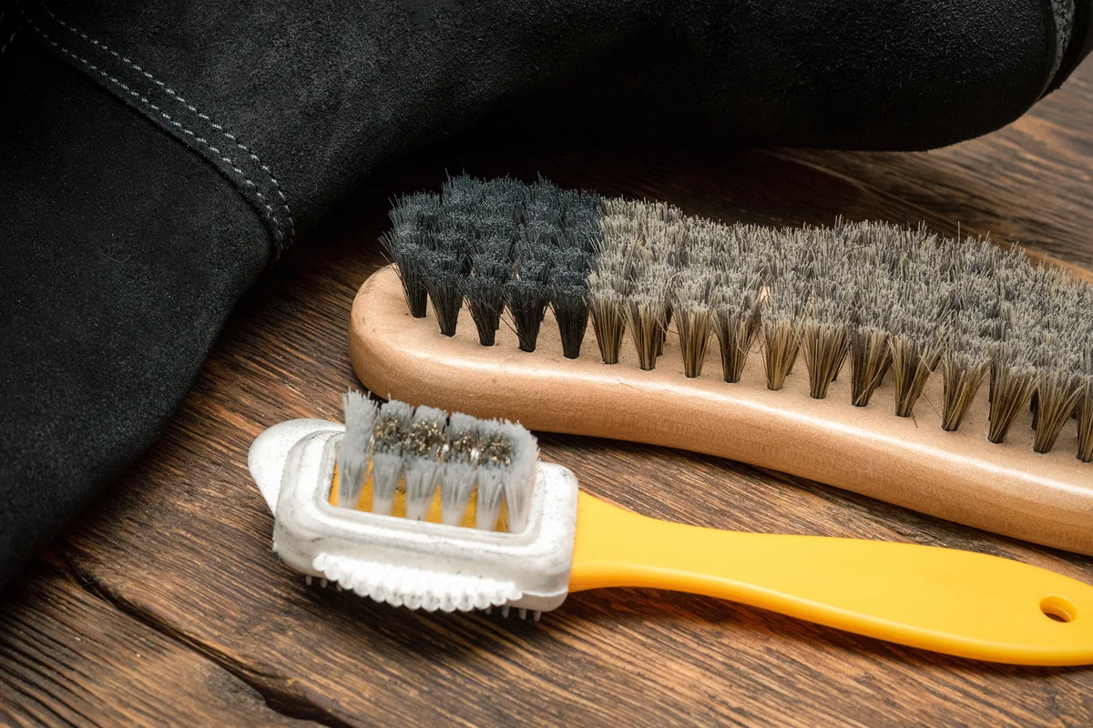 Cleaning suede boots with a shoe brush