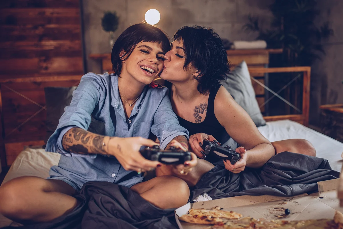 Couple playing video games in bed