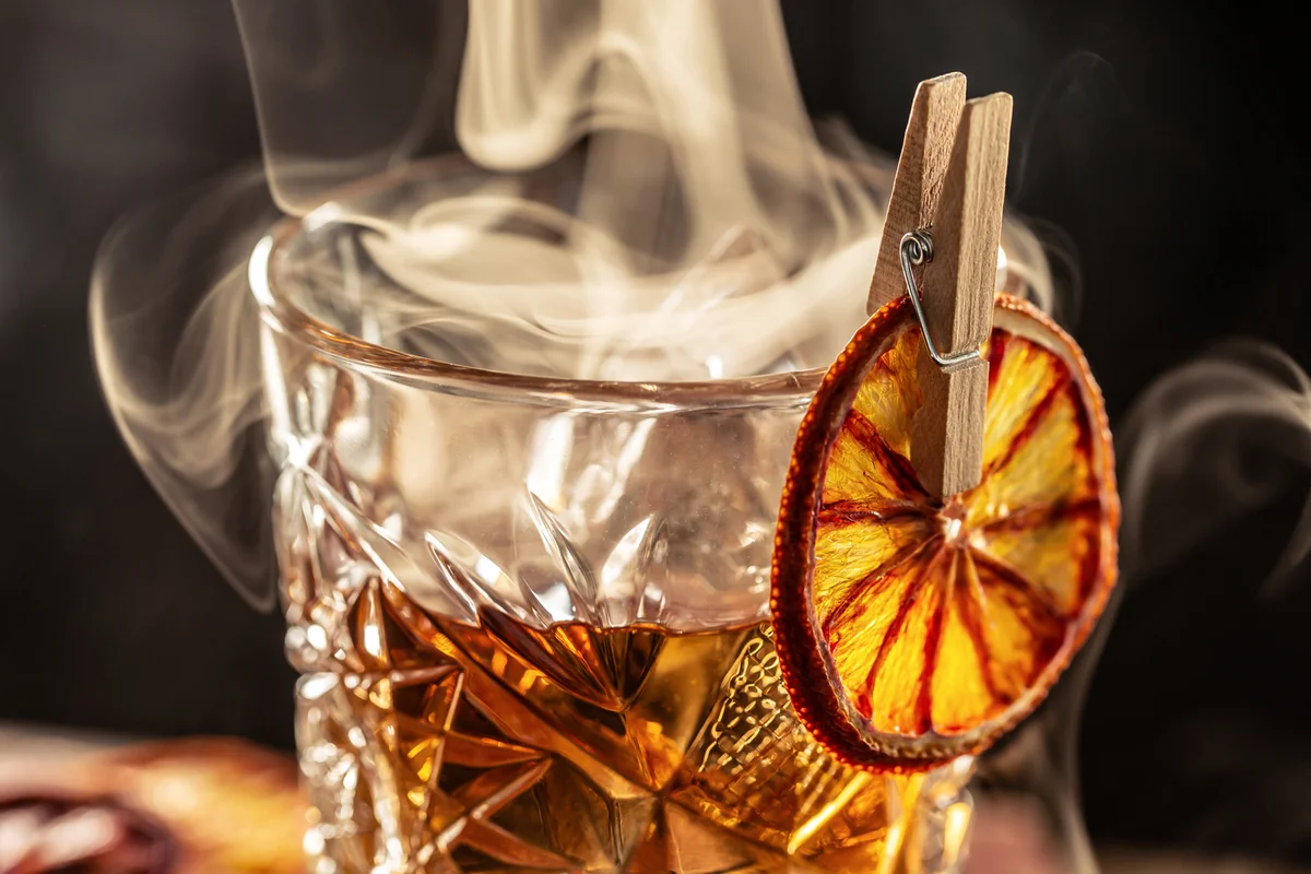 Smoked old-fashioned cocktail with dried orange slice