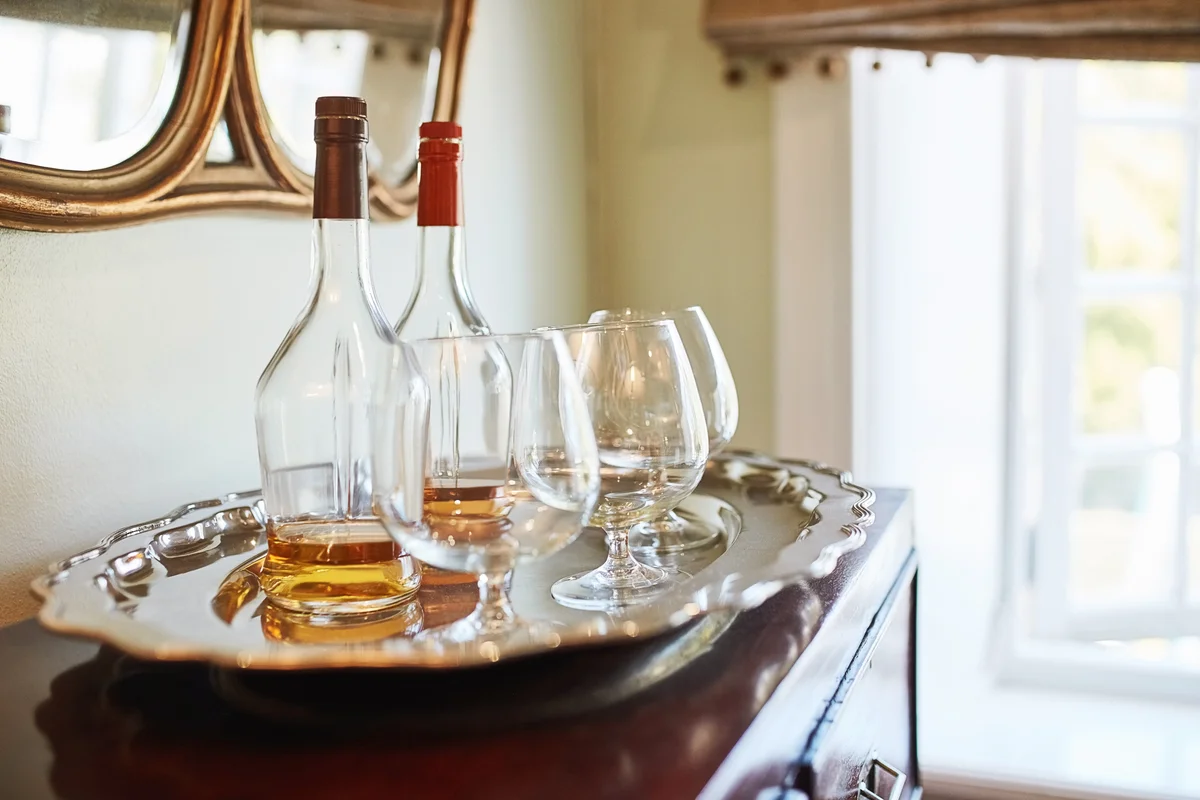 Whiskey bottles and glasses over bar cabinet