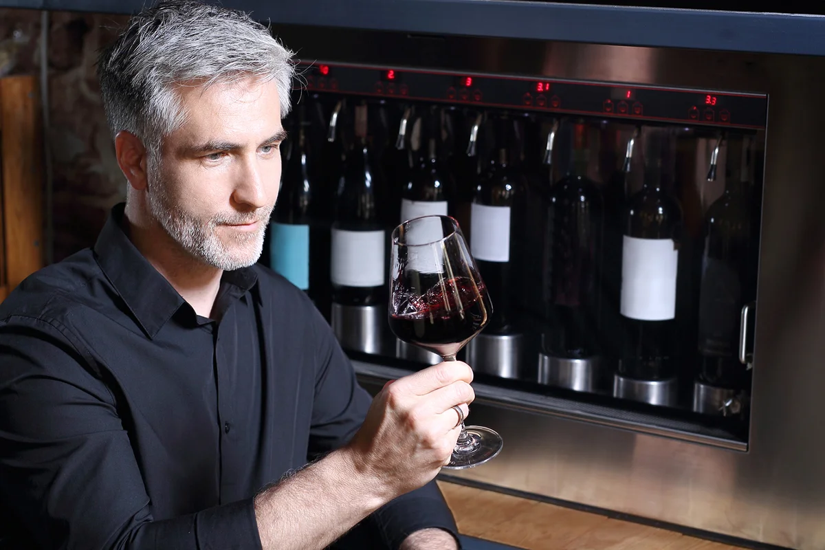 Red wine, man evaluates the color of wine in a glass