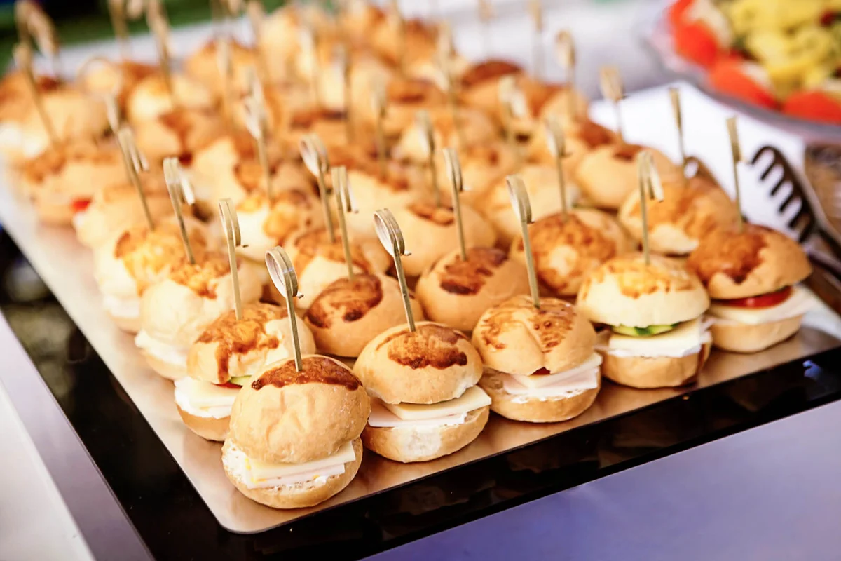 Tray of ham and cheese sliders with cucumber and tomato