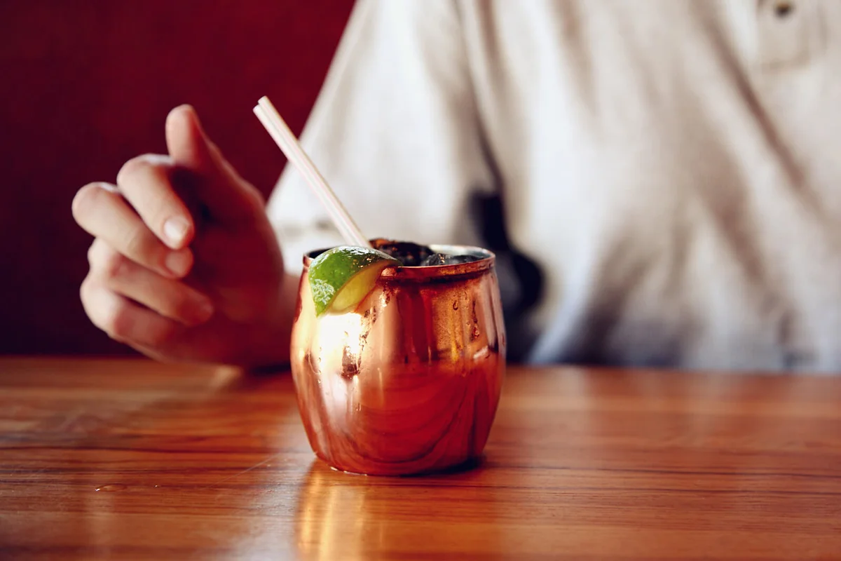 Midsection Of Woman With Moscow Mule At Table
