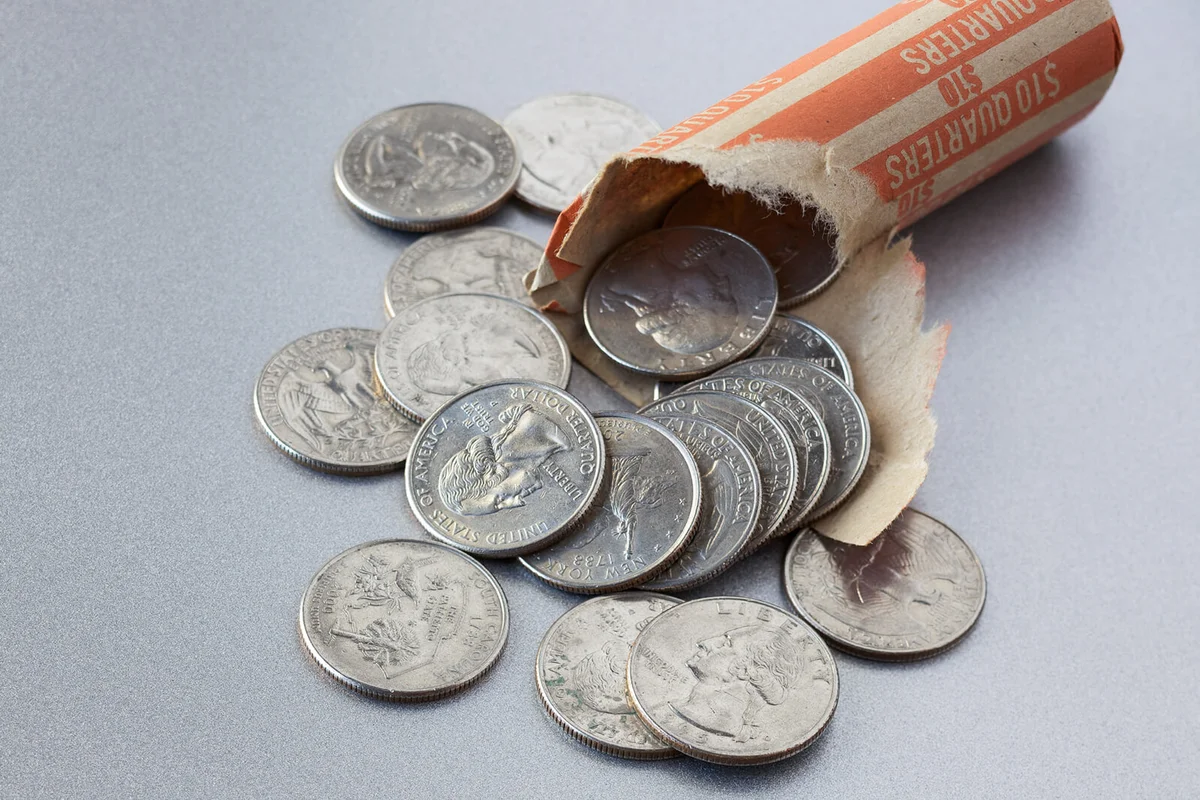 Open roll of US quarter dollar coins on steel surface