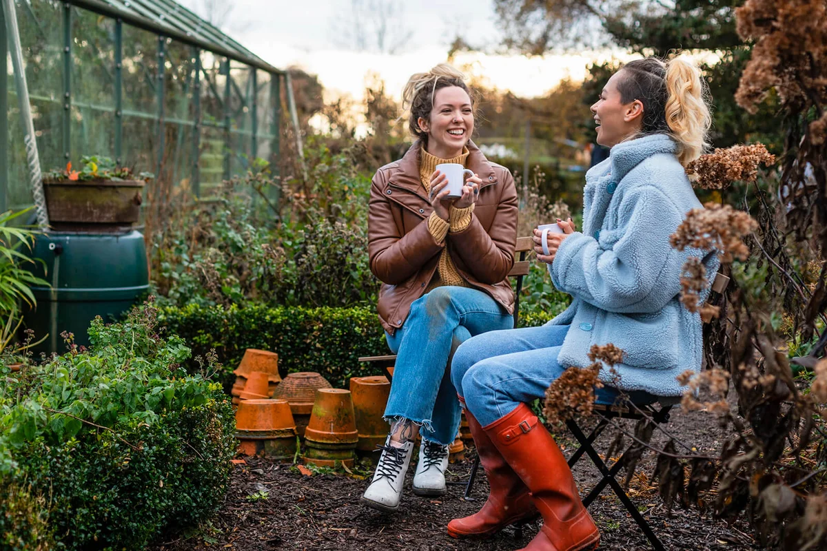 Women sitting outdoors wearing warm casual clothing on a sunny cold winters day