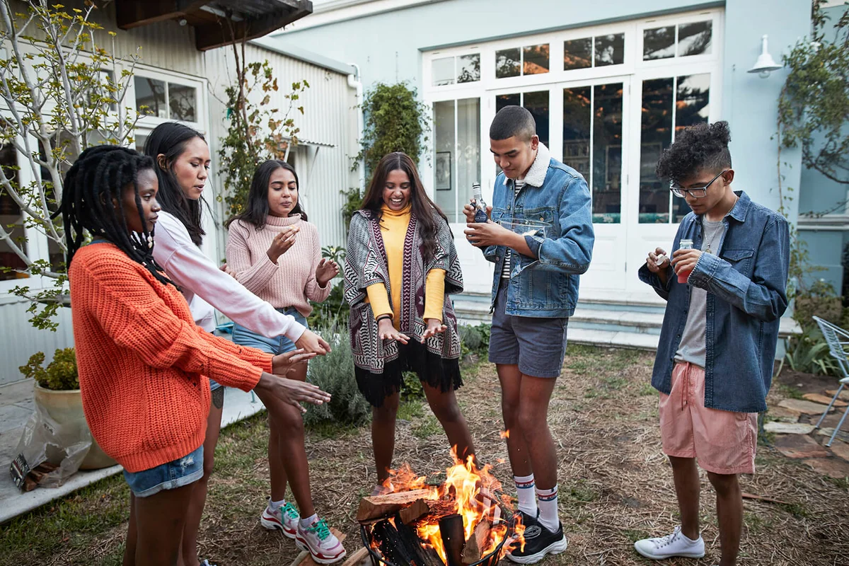 Friends warming hands over bonfire