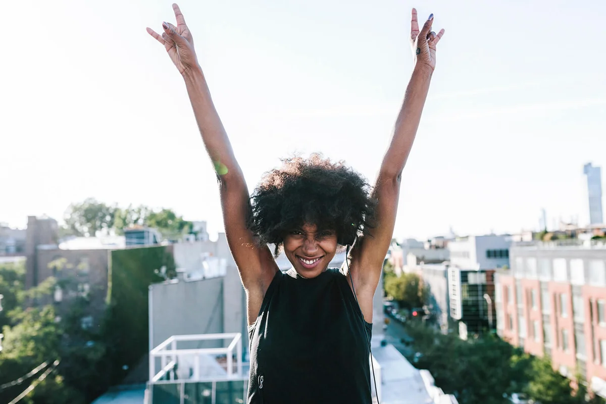 Happy young woman standing on rooftop