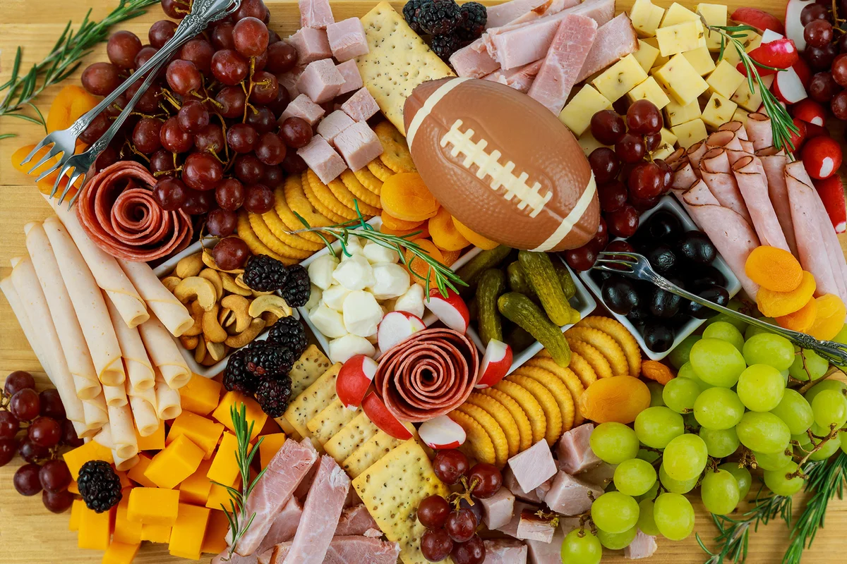 Charcuterie board with cheese, grape, ham and crackers