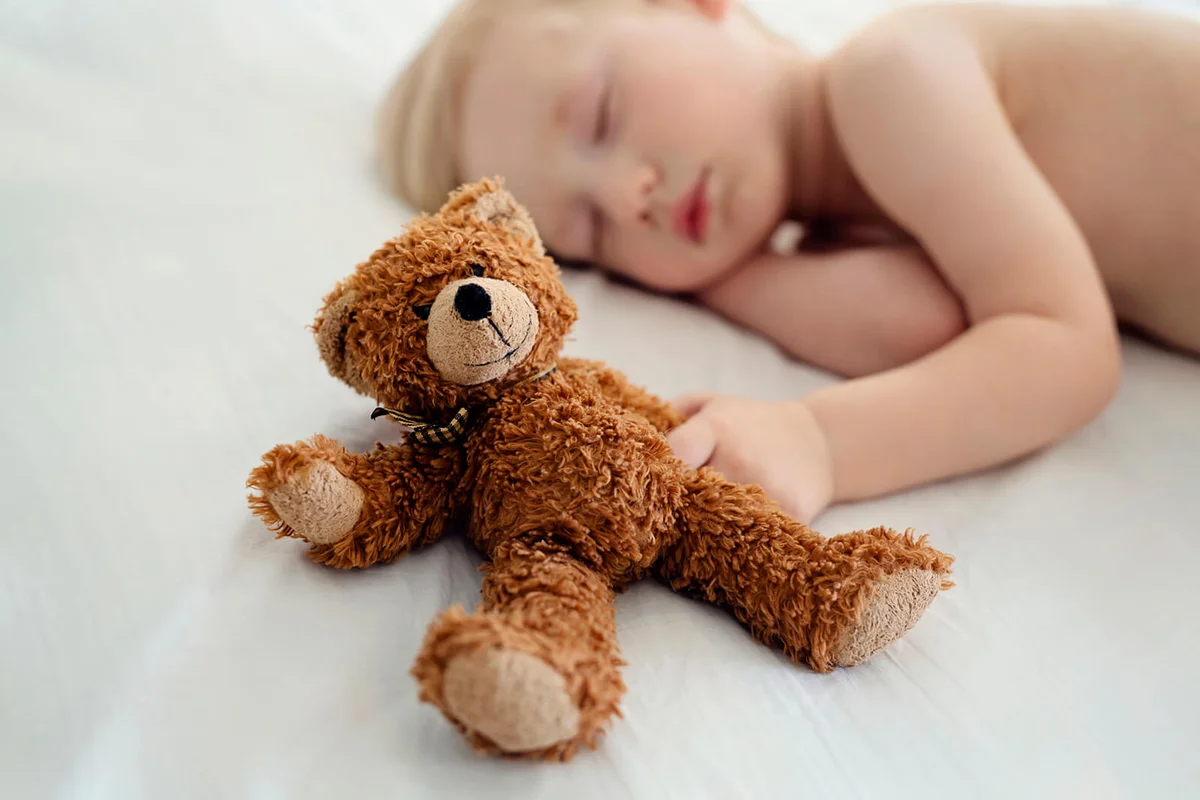 Small boy sleeping with teddy bear