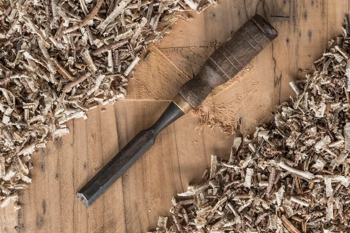Directly Above Shot Of Chisel And Wood Shavings On Table