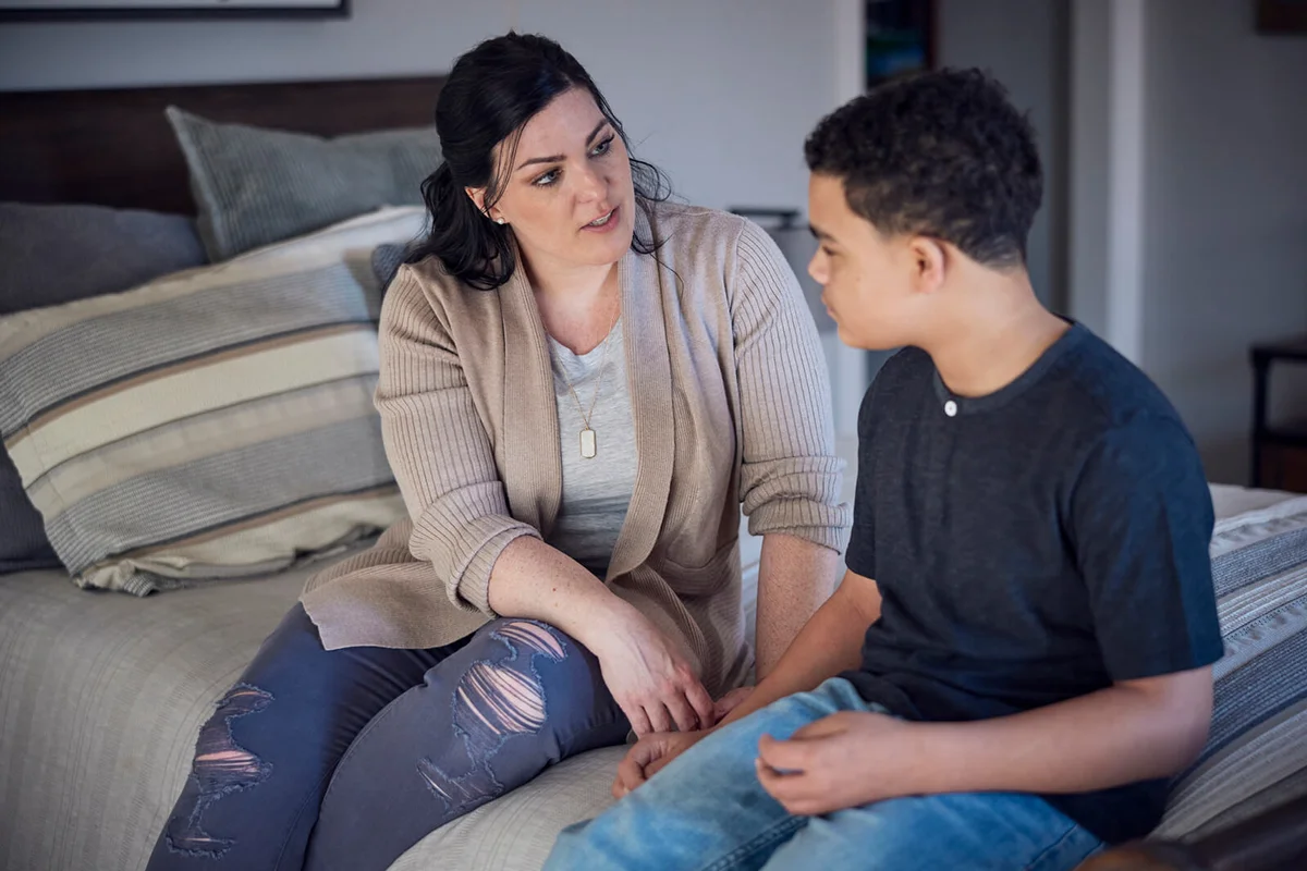 mother talking with son in bedroom