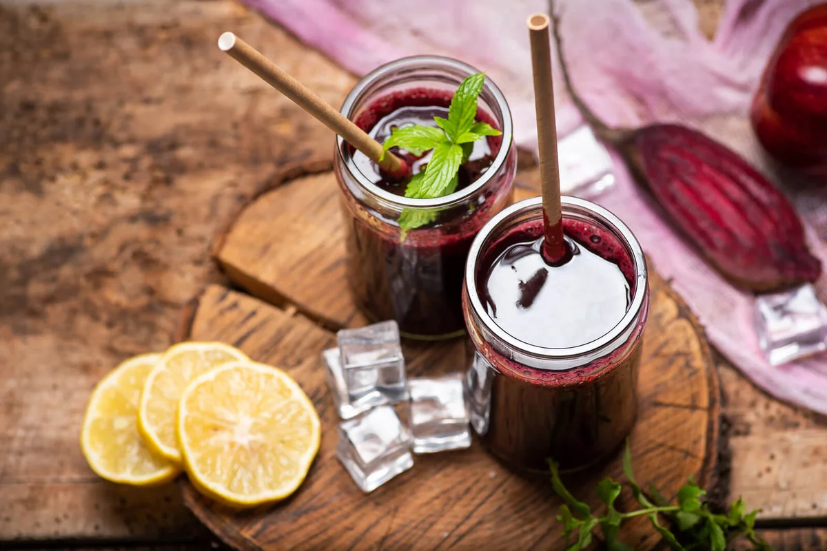 Beetroot juice in a glass with ice and lime fruit