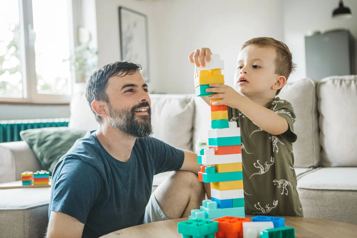 Father and son playing with color blocks at home