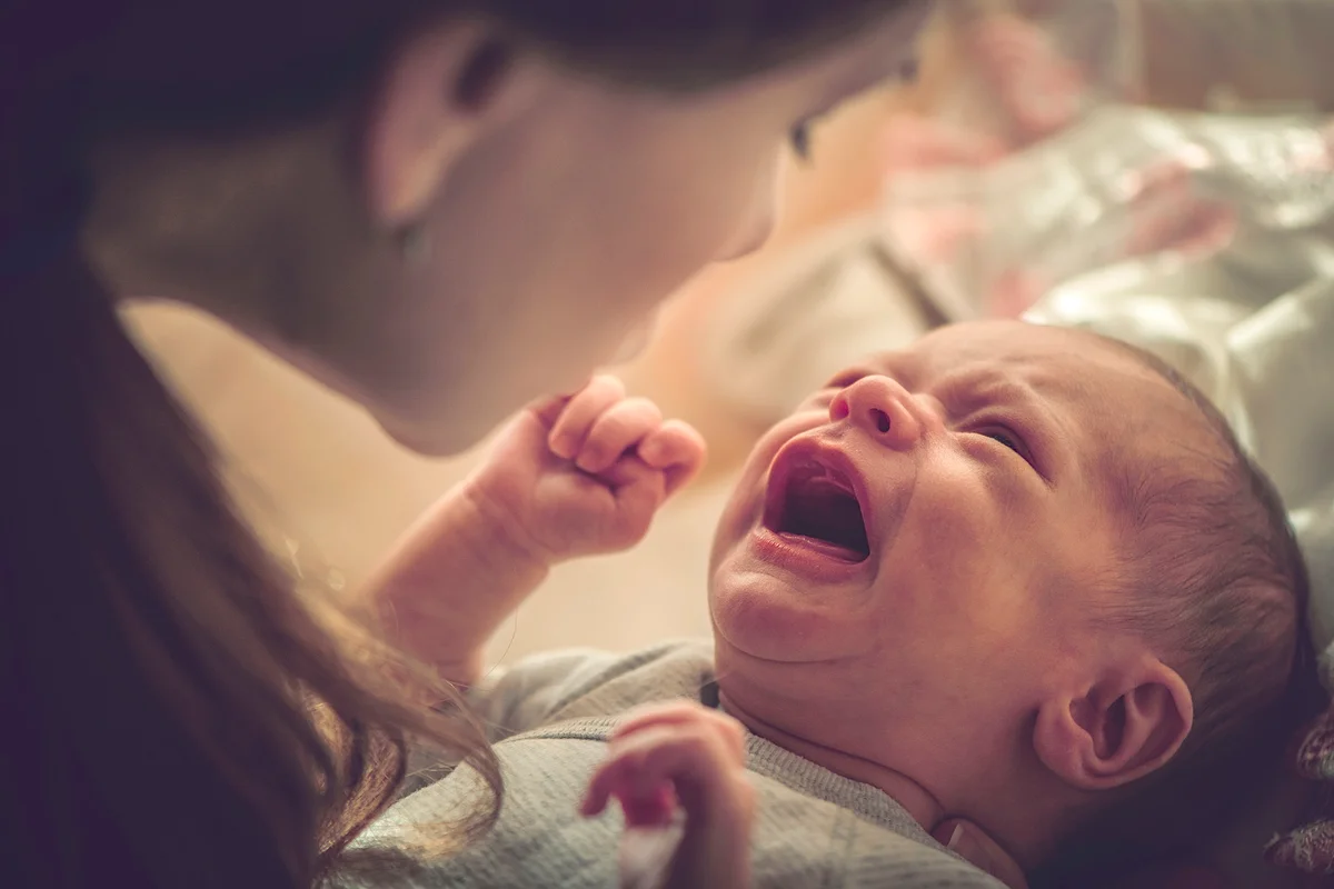 Mother with her newborn baby girl crying