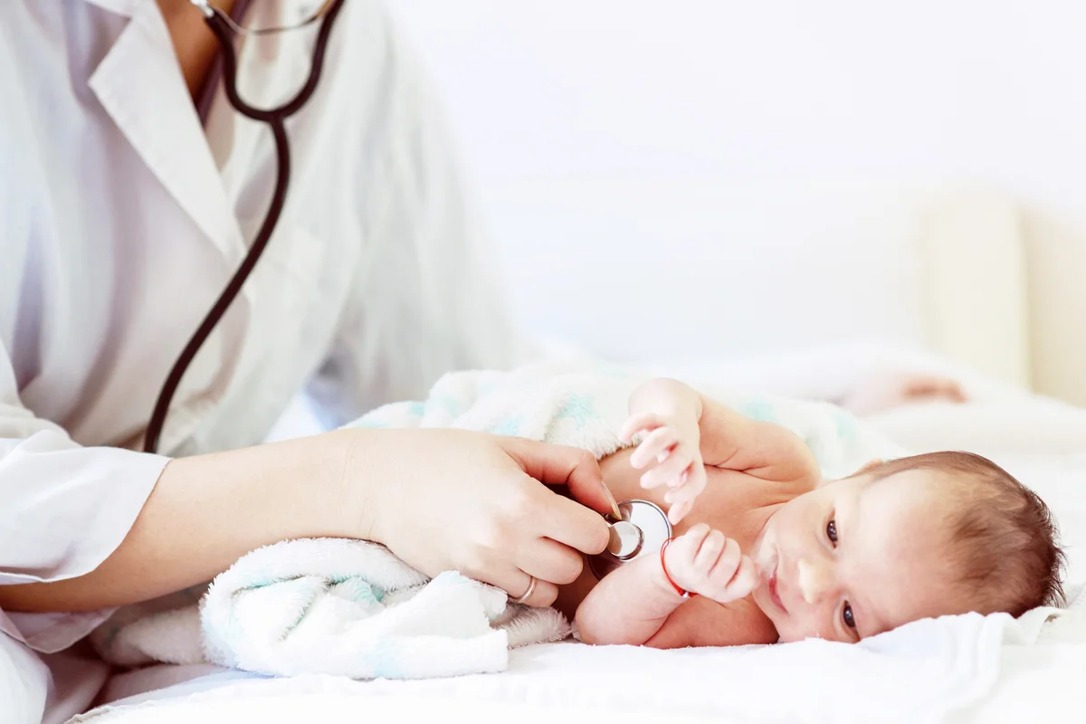 Female doctor examines infant with stethoscope