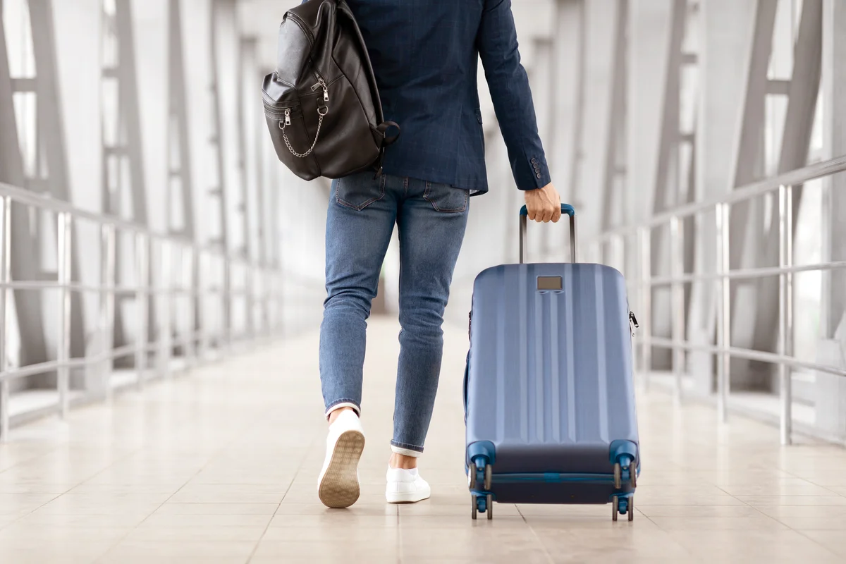 Man With Bag And Suitcase Walking In Airport
